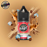 A 30ml bottle of Flavour Beast E-liquid in iced coffee flavour, surrounded by coffee beans and ice cubes, on a beige background. Underground Vapes Woodstock and London