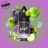 A 30ml bottle of Flavour Beast E-liquid in grape and green apple ice flavour, surrounded by purple grapes, apple slices and ice cubes, on a bright purple and green background. Underground Vapes Woodstock and London