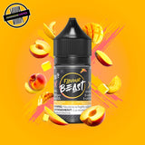 A 30ml bottle of Flavour Beast E-liquid in mango peach flavour, surrounded by mango and peach slices, and ice cubes, on a bright yellow and pink background. Underground Vapes Woodstock and London